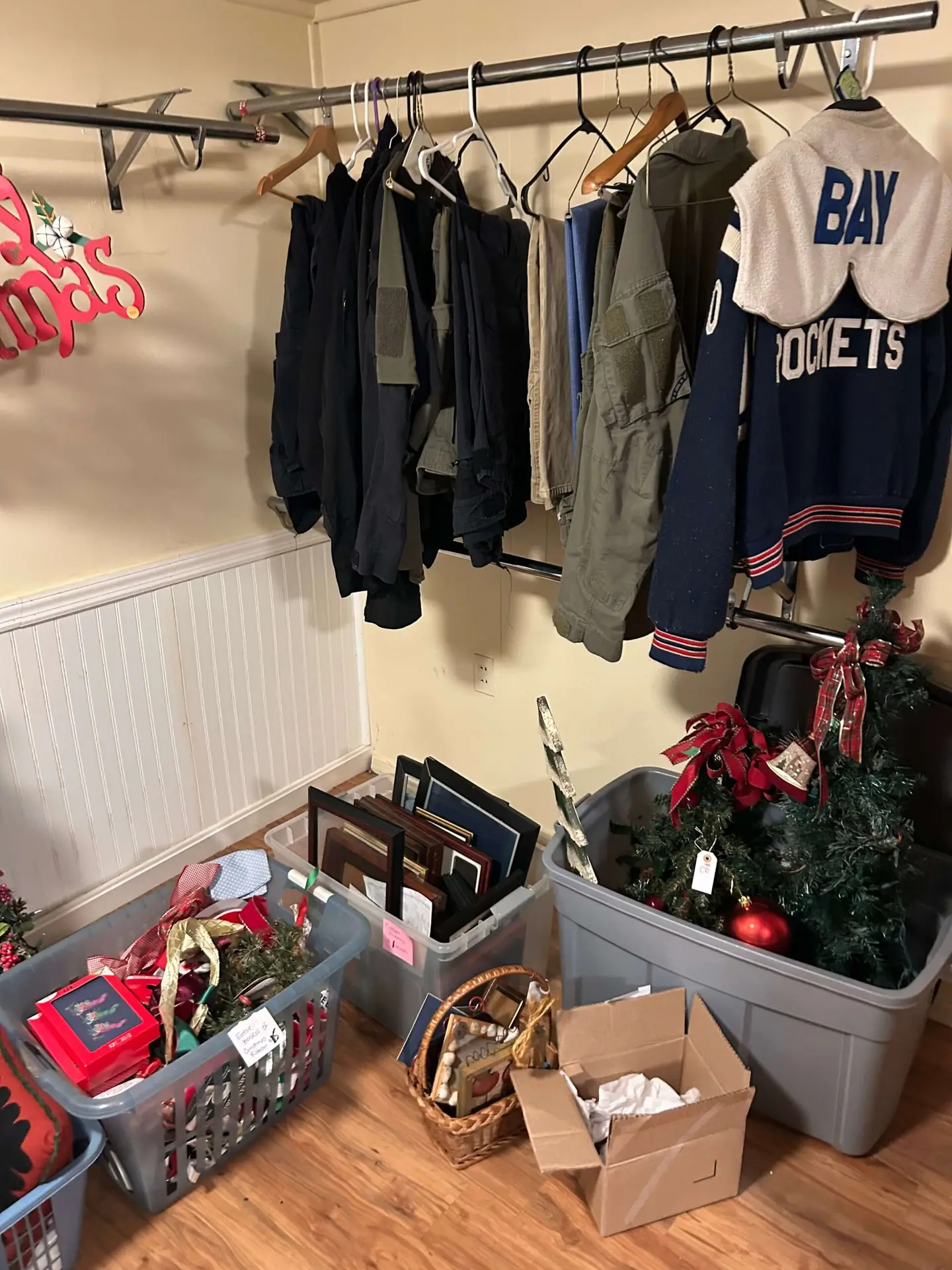orting clothes, including a local Bay Rockets jacket, and holiday decor into storage totes during a residential estate cleanout in Bay Village, Ohio.