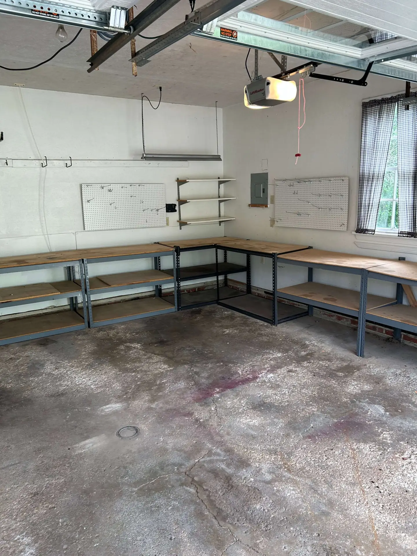 he same Bay Village garage completely cleared of junk, showing empty workbenches and a swept concrete floor after a professional cleanout.