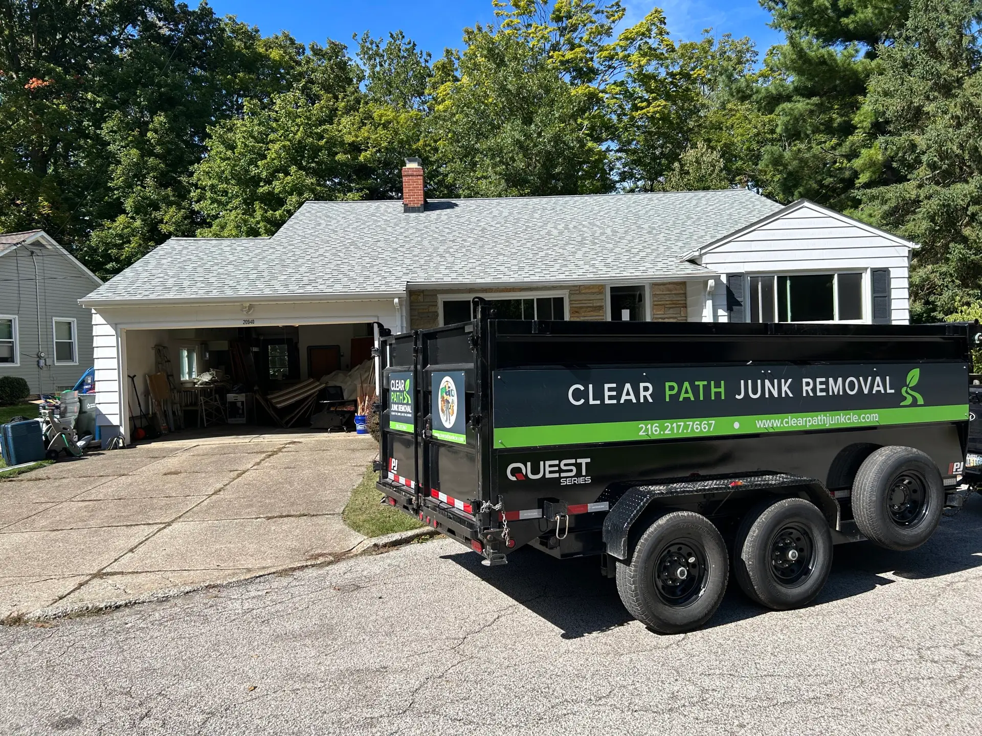 The Clear Path Junk Removal branded dump trailer parked in a residential driveway, ready to begin a home cleanout in Fairview Park, Ohio.