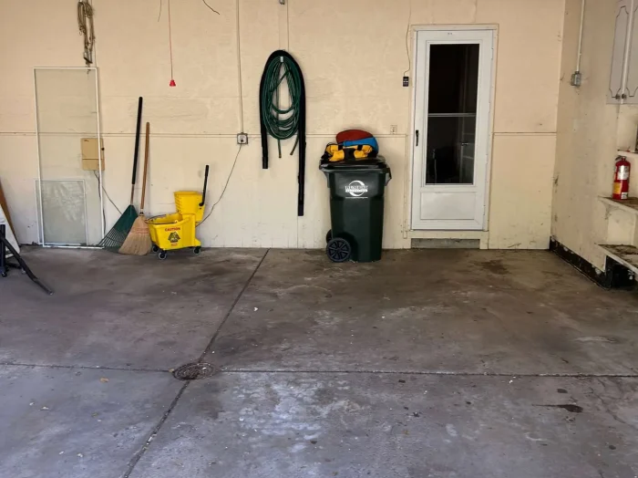 After photo of a completely empty, clean-swept residential two-car garage following a professional junk hauling service.